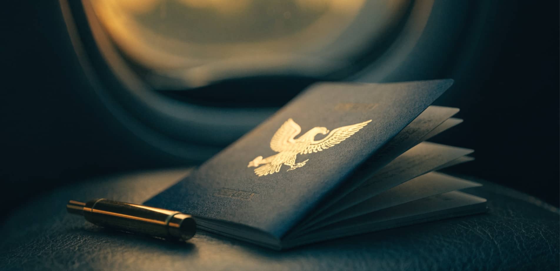 U.S. passport and gold pen on an airplane tray for a first-time adult passport